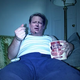 A depressed Gore finishes off a large container of ice cream while watching C-SPAN.